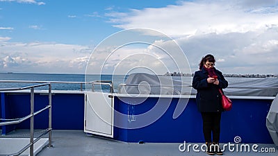 Karsikaya, Izmir, Turkey- 02/06/2020: Female passenger on the KarÅŸÄ±yaka Ferry is looking at her phone. Editorial Stock Photo